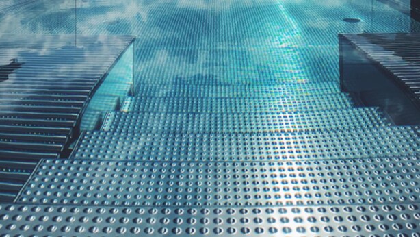 A swimming pool with a mountain view, surrounded by a glass enclosure. - Hotel Am Hopfensee (Fuessen)