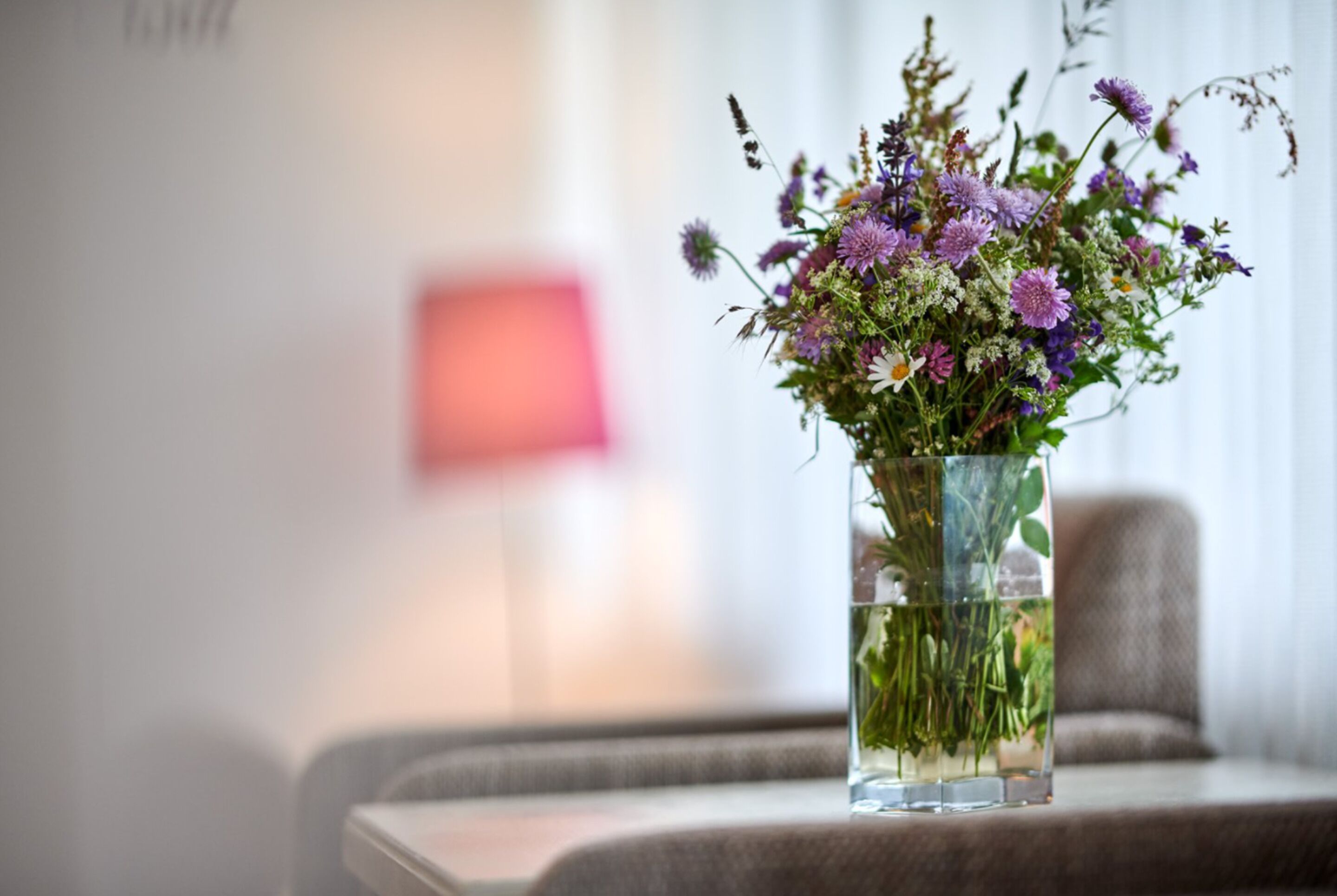A clear glass vase with a floral arrangement on a table.