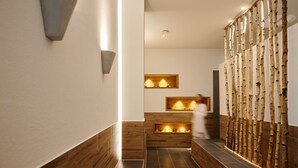 Un pasillo moderno con paneles de madera, iluminación empotrada y una pared decorativa con elementos verticales.