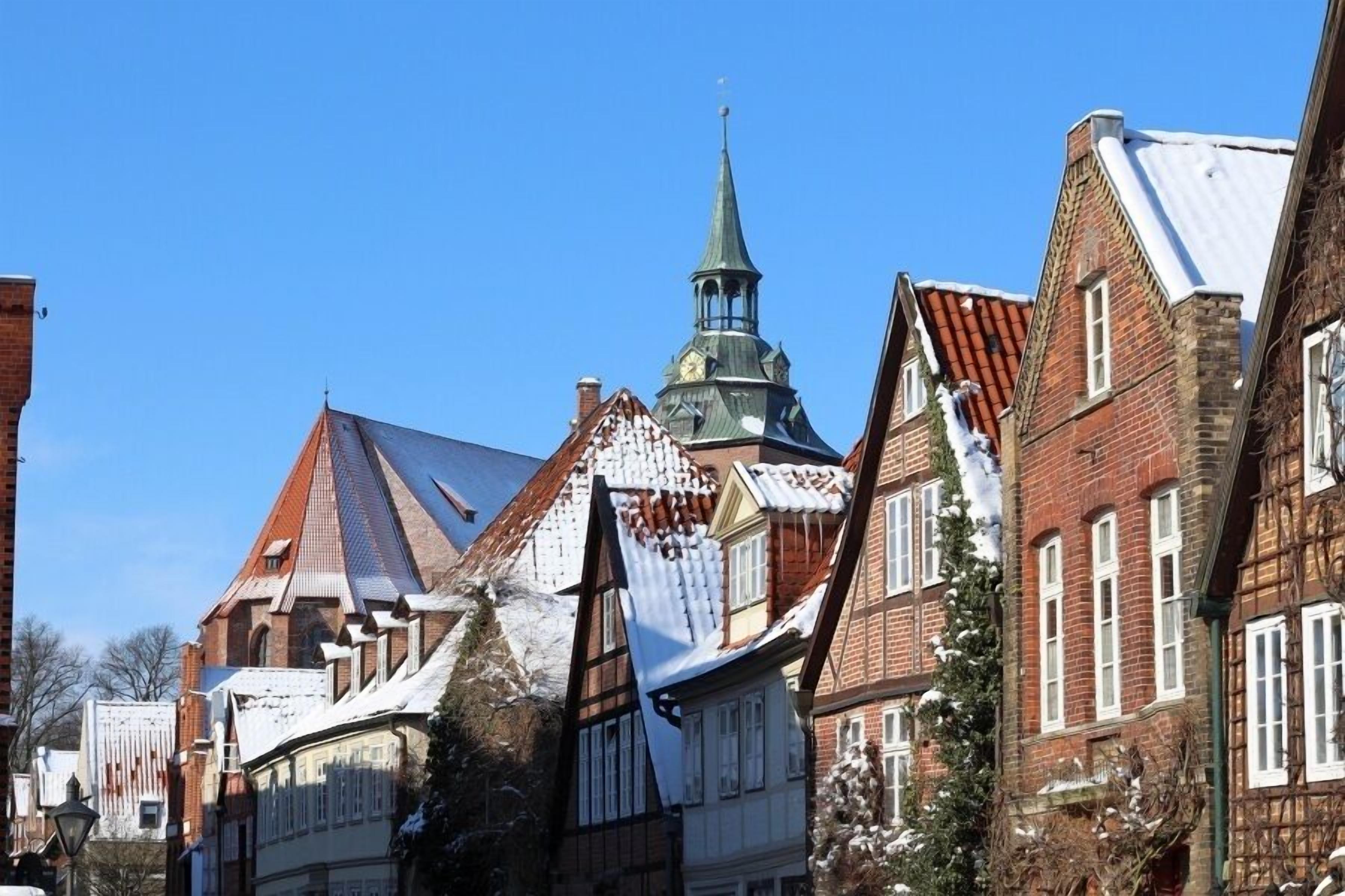 A traditional European town with historic buildings, including a church with a spire.