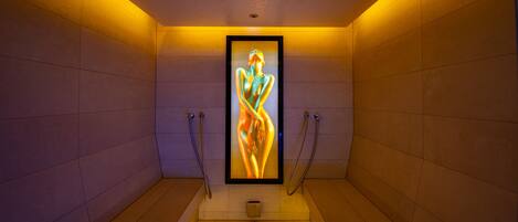 A narrow, tiled bathroom with a framed artwork of a human figure.