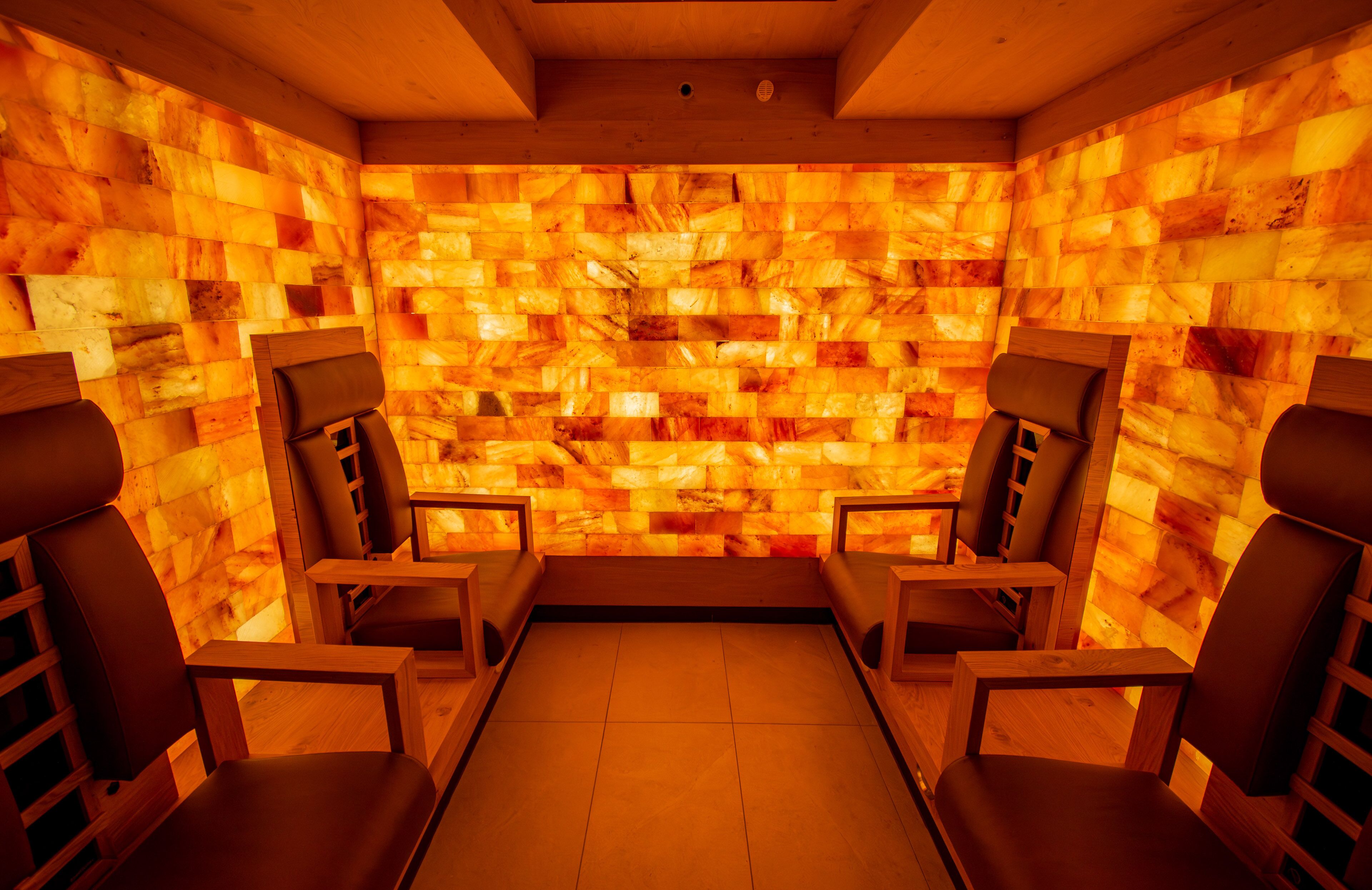Una sala de sauna con paredes y dos sillas de madera.