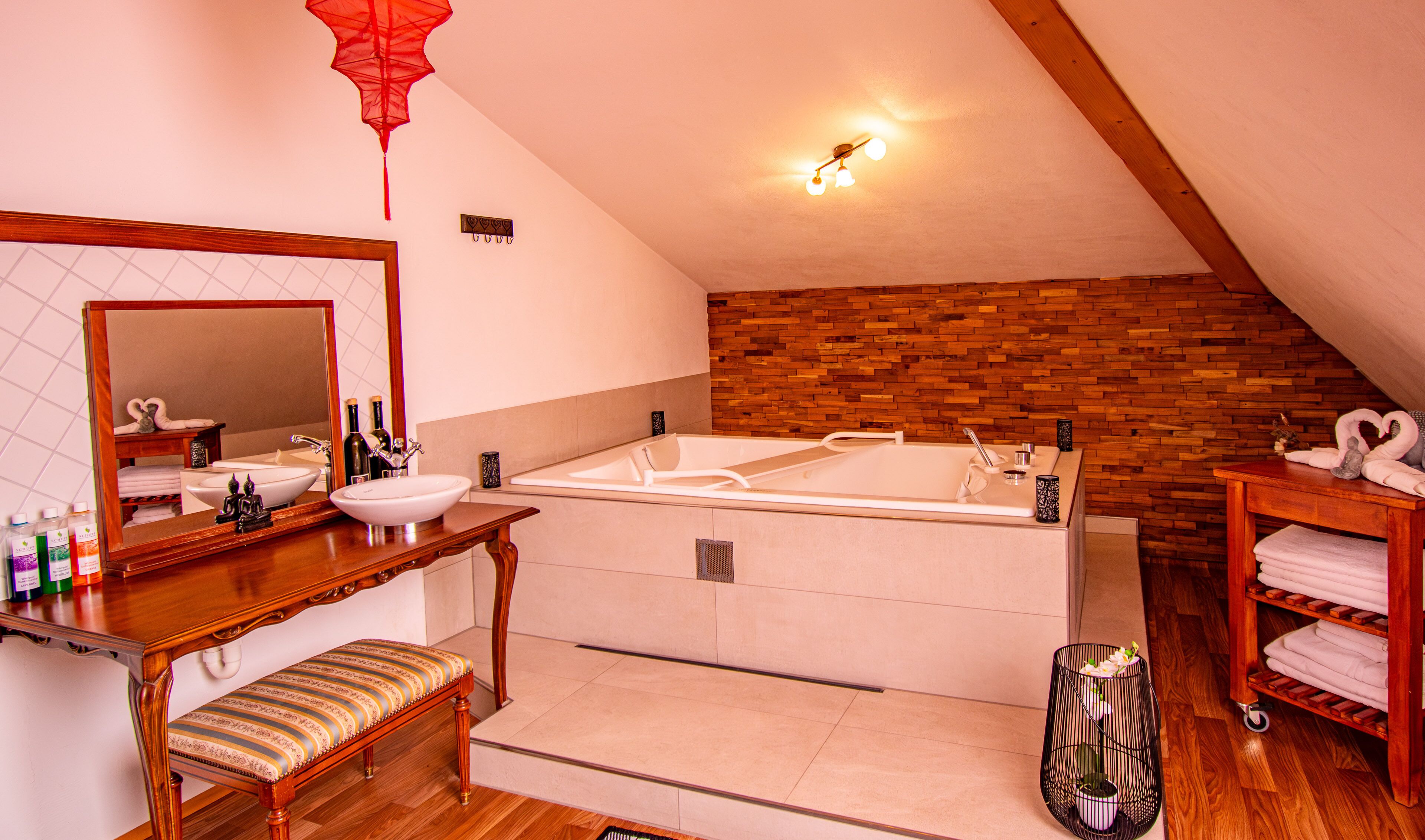 Une salle de bain moderne avec un banc en bois, un grand miroir, un lavabo et une baignoire.
