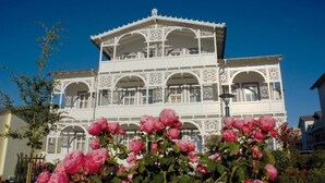 A multi-story building with ornate white balconies and arched windows. - Kur- und Wellness Hotel Mönchgut (Göhren)