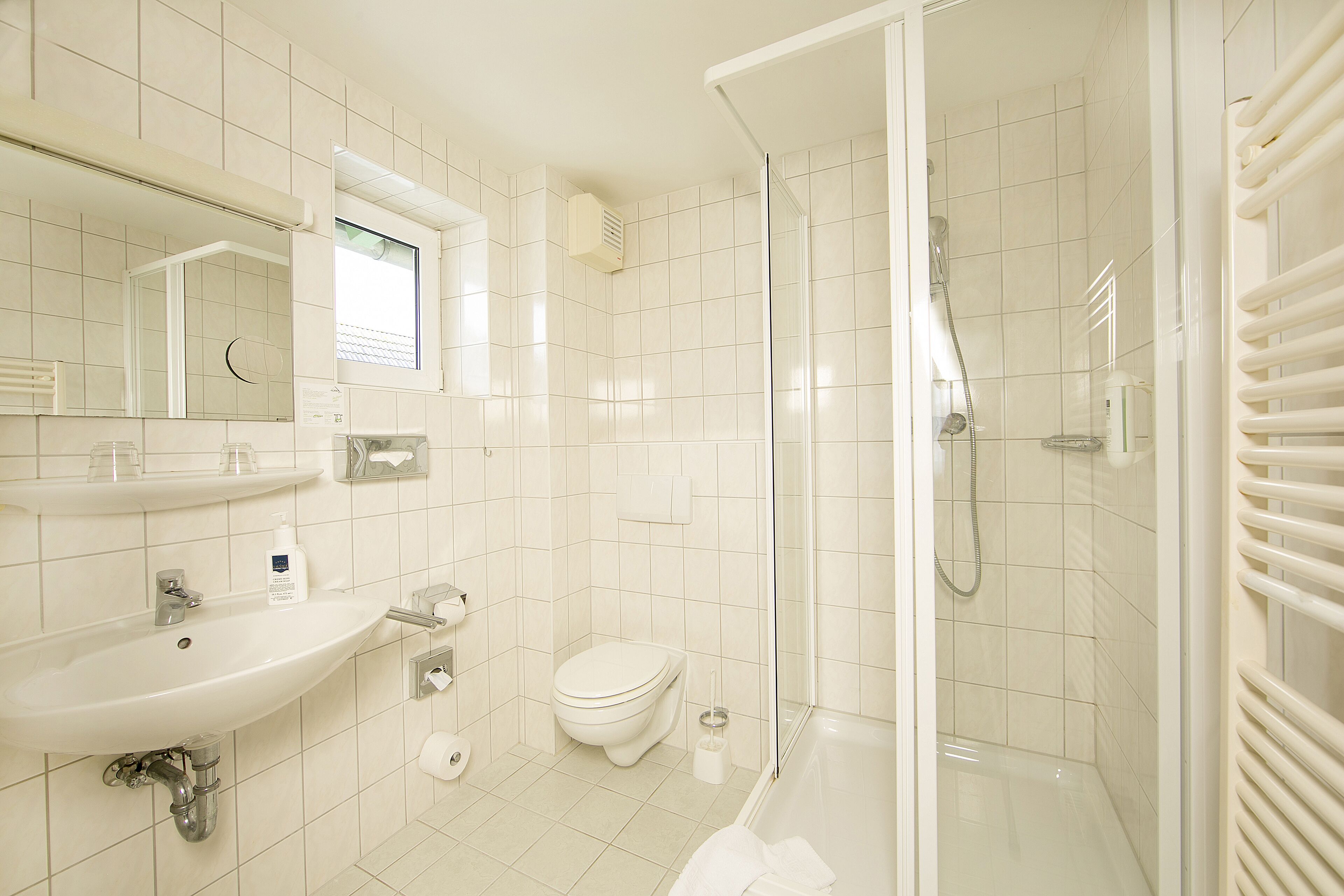 Une salle de bain moderne avec un lavabo, des toilettes et une douche à parois de verre.