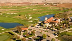 A golf course with a clubhouse, a lake, and surrounding hills. - Best Western Plus Vineyard Inn (Livermore)