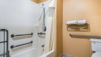 A bathroom with a bathtub, a toilet, and a shower. There are grab bars installed near the bathtub and toilet.