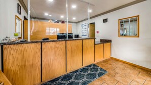 A reception area with a wooden counter, a reception desk, and a tiled floor. - Americas Best Value Inn Ukiah (Ukiah)