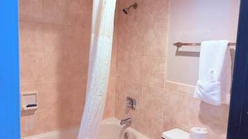 Un baño con bañera, inodoro y cortina de ducha.