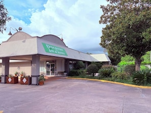 A hotel with a sign for 'Discovery Ann & Suites' and a covered entrance. - Discovery Inn Lafayette Airport I-10 (Lafayette)