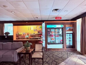 A hotel lobby with a seating area, a refreshment bar, and a beverage refrigerator. - Discovery Inn Lafayette Airport I-10 (Lafayette)