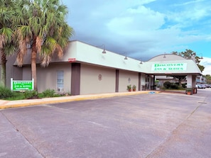 Un hotel llamado 'Discovery Inn & Suites' con un estacionamiento al frente.