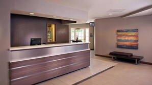 A reception desk with a computer, a bench, and a restroom sign.