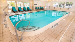 Una piscina interior amb aigua cristal·lina, un senyalitzador de prohibició de salts i una marca de profunditat de 1 metre i 83 centímetres.