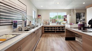 A modern kitchen with a marble countertop, a glass display case, and a window providing natural light. - Residence Inn by Marriott Vacaville (Vacaville)