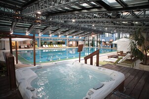 Una piscina techada, sillones reclinables de piscina