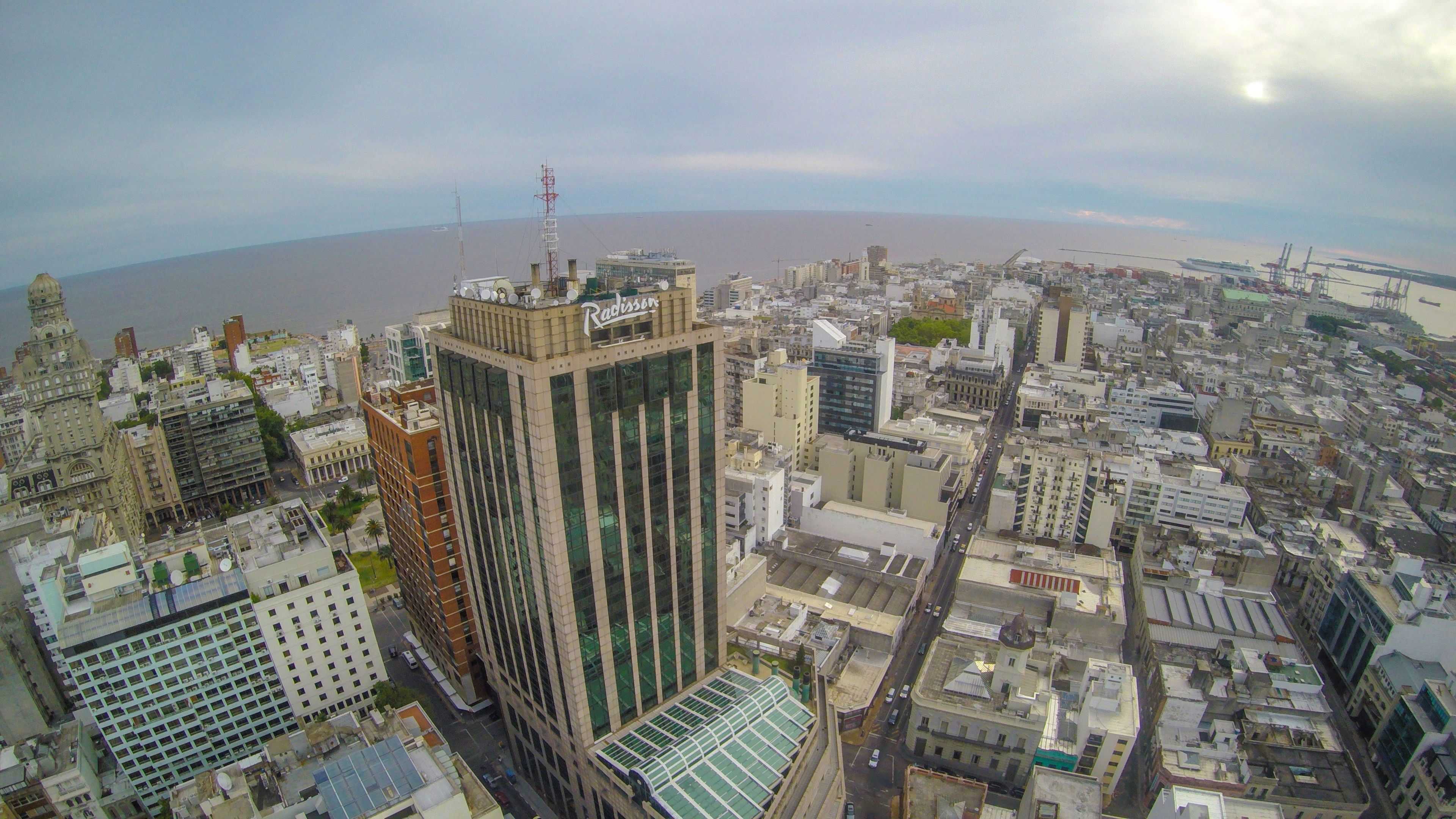 Un edificio alto con fachada de vidrio y una terraza en la azotea.