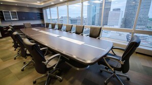 A conference room with a long table, chairs, and large windows with a city view. - Radisson Hotel Winnipeg Downtown (Winnipeg)