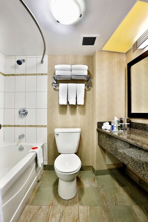 Een bad/douchecombinatie, designer toiletartikelen, een haardroger