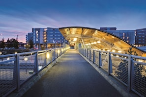 A pedestrian bridge with a curved roof, metal railings, and lights. - Radisson Blu Airport Hotel, Oslo Gardermoen (Ullensaker)