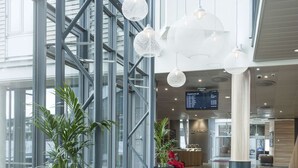A modern lobby with large windows, seating areas, and a departure board. - Radisson Blu Airport Hotel, Oslo Gardermoen (Ullensaker)