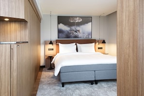 A modern bedroom with a grey bed, wooden wardrobe, and a large cloud-themed artwork above the bed. - Radisson Blu Airport Hotel, Oslo Gardermoen (Ullensaker)