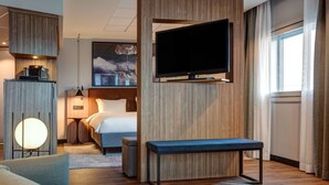 A hotel room with a bed, a TV mounted on the wall, a sofa, a coffee machine, and a lamp. - Radisson Blu Airport Hotel, Oslo Gardermoen (Ullensaker)