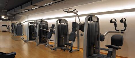 Et fitnesscenter med diverse træningsmaskiner og bænke.