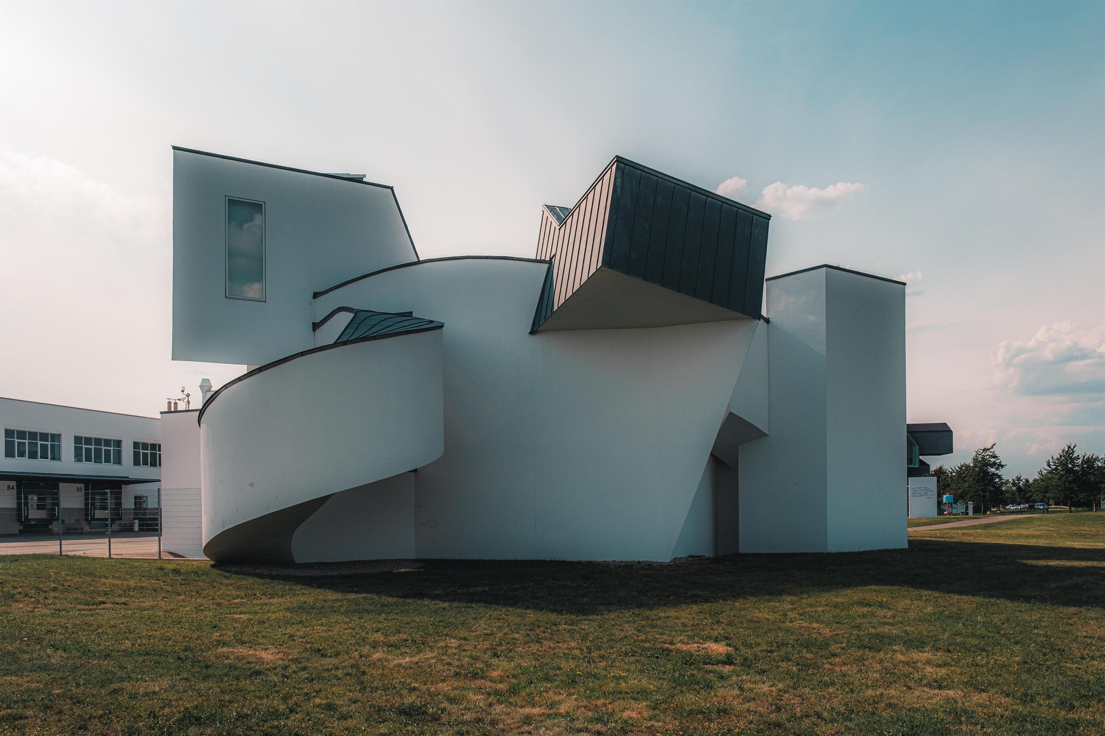 A modern architectural building with a unique curved design, large windows, and a flat roof.