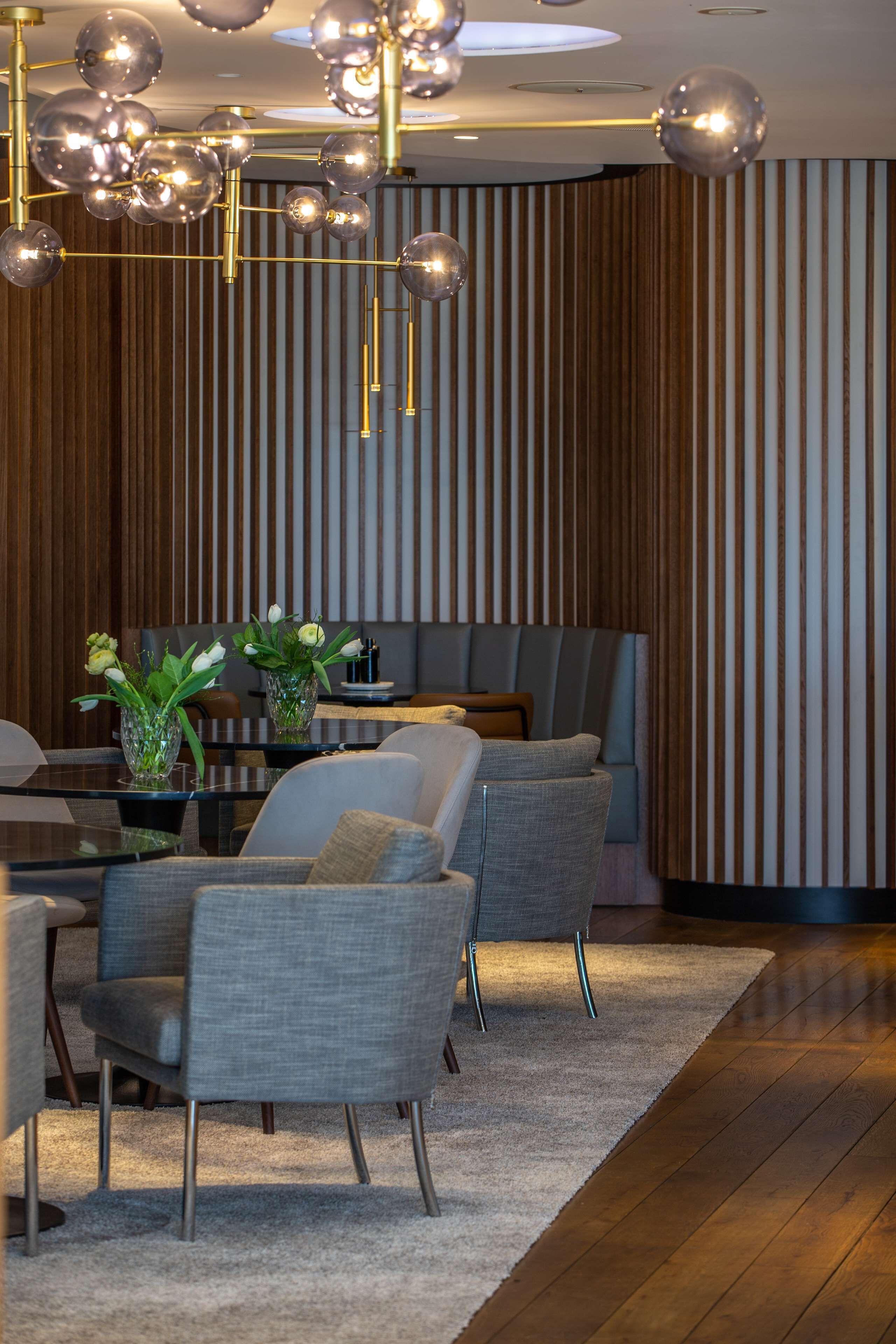 A modern interior with a dining area, seating, and a decorative ceiling light fixture.