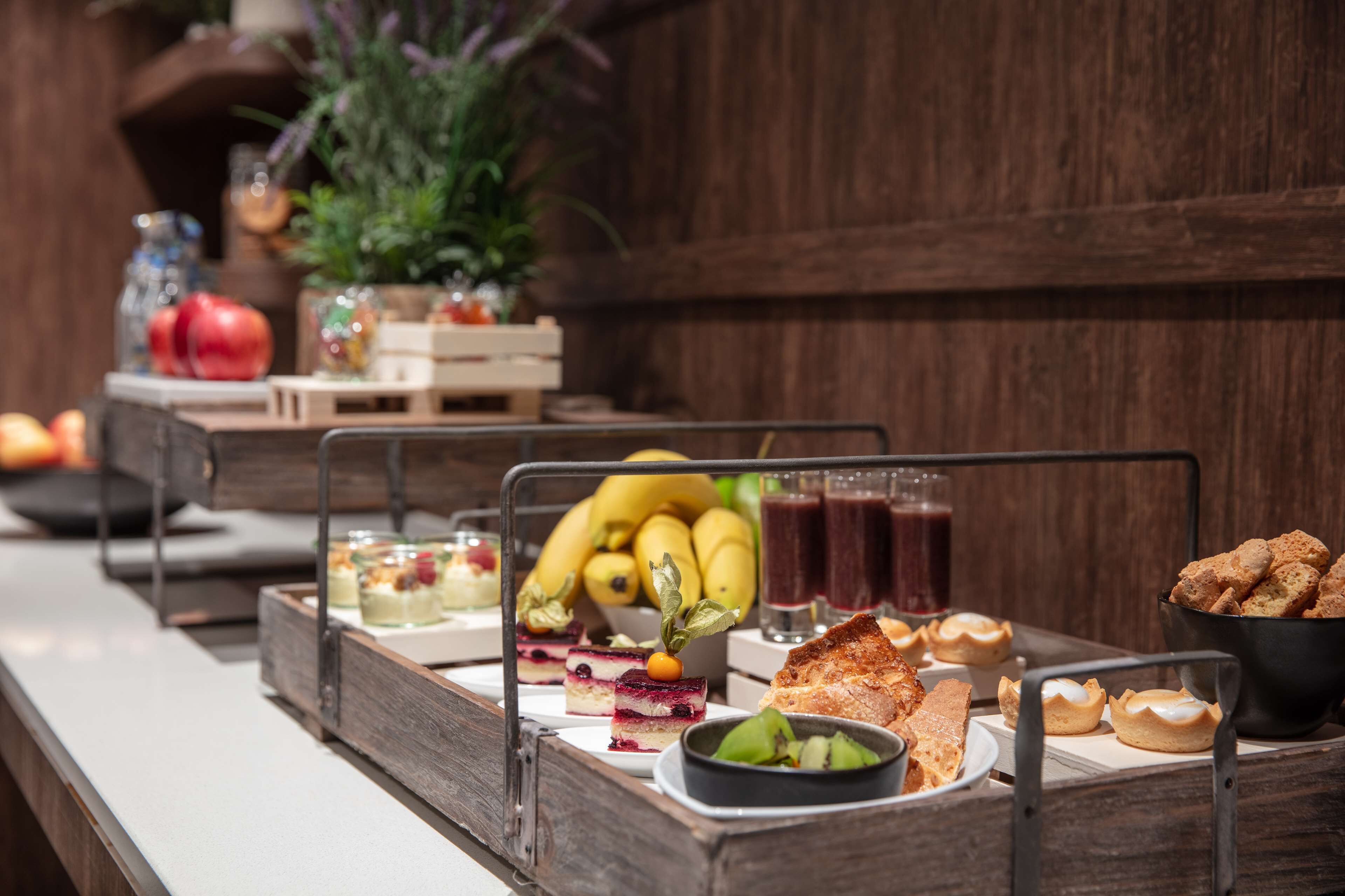 A buffet table with various food items, including fruits, desserts, and beverages.