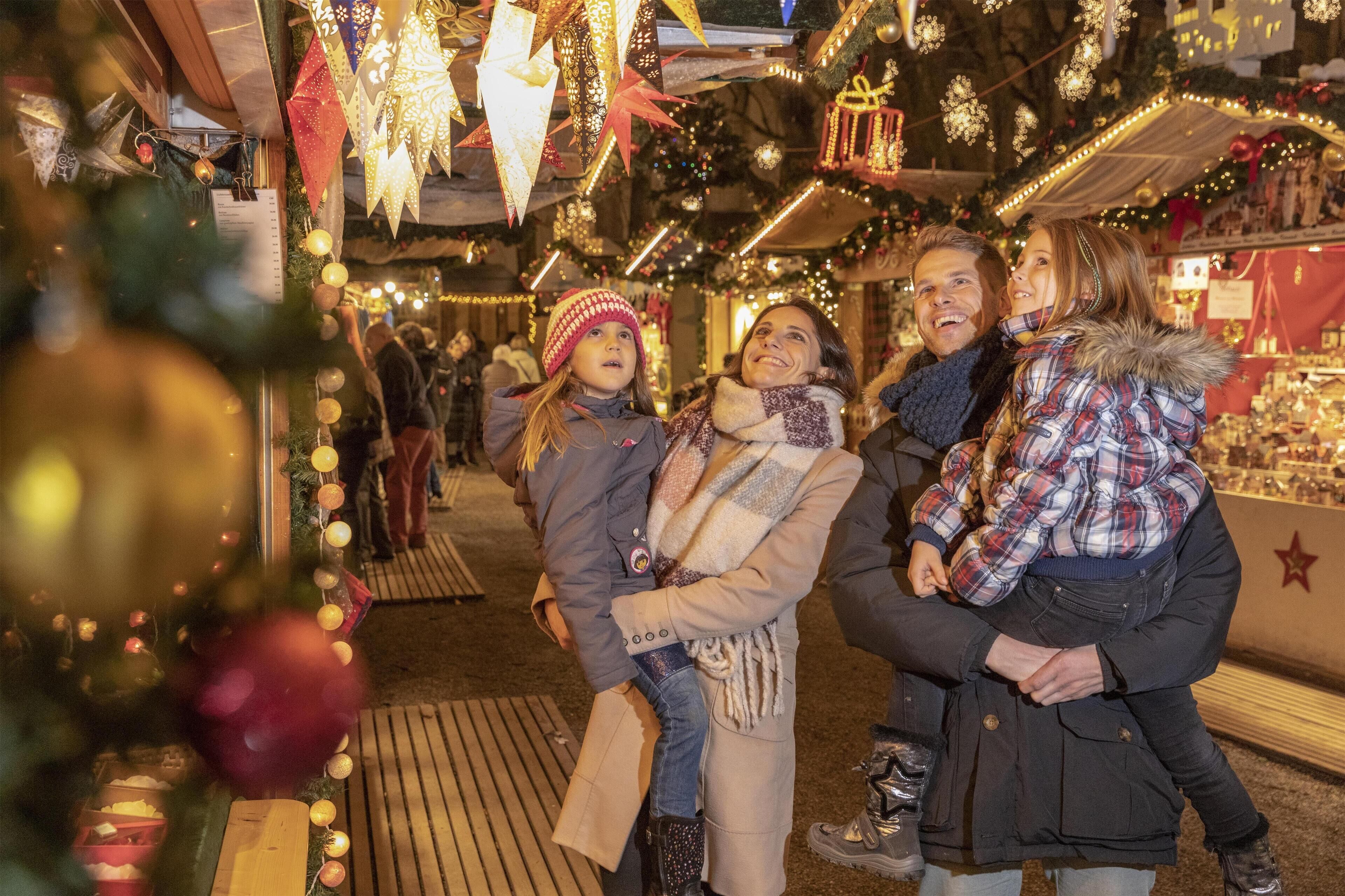 A festive indoor market with wooden benches and hanging decorations.