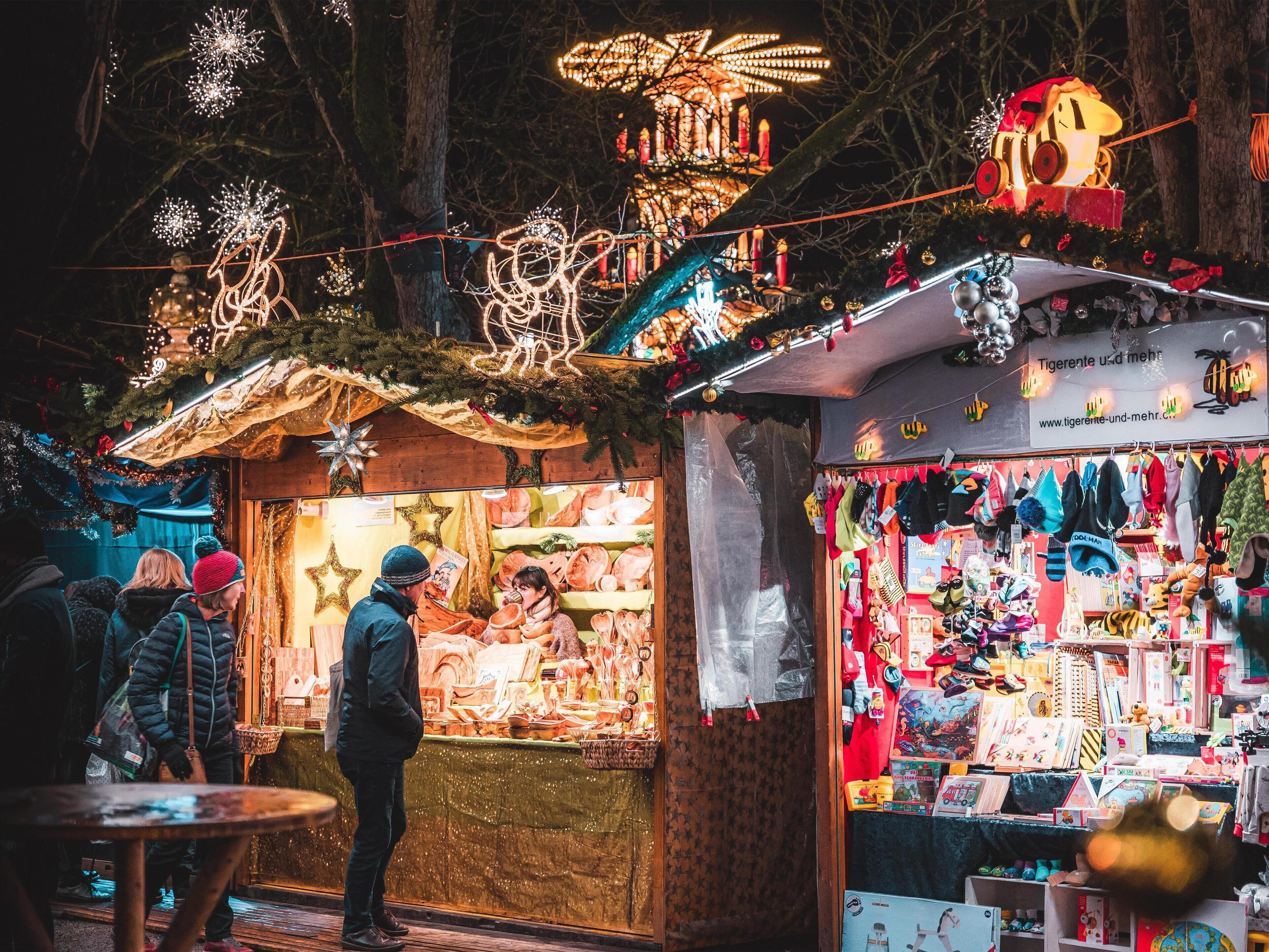 Un puesto de mercado festivo con varios artículos a la venta, entre ellos juguetes y artesanías.