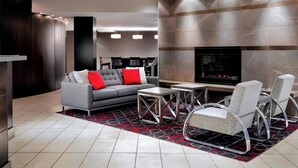 Una sala de estar moderna con sofá, sillas, chimenea y una zona de cocina.