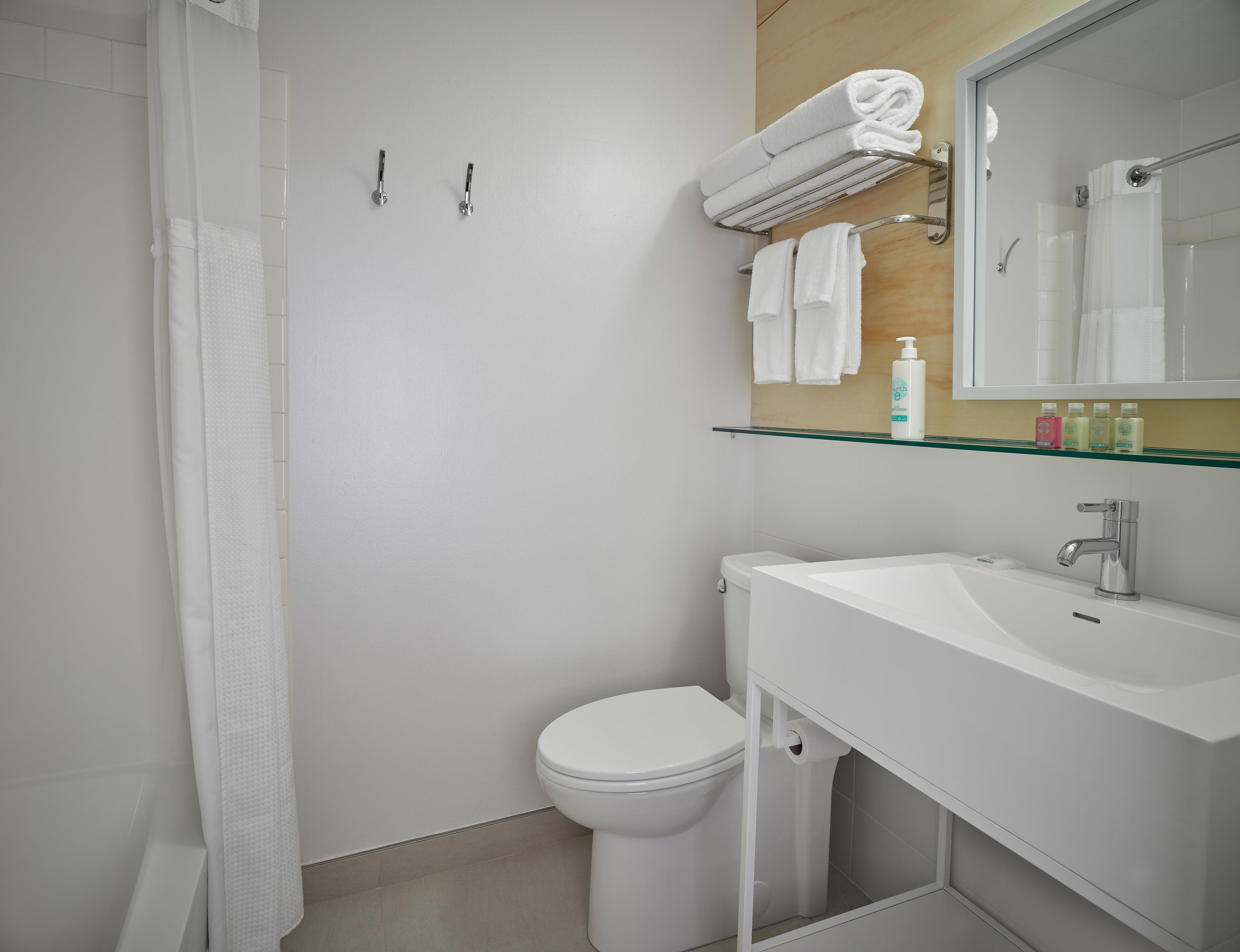 Une salle de bain moderne équipée de toilettes, d’un lavabo et d’un espace douche.