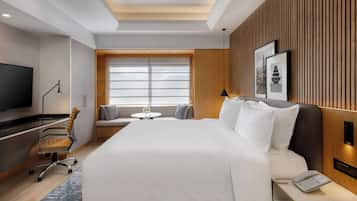 Relax in a serene space with a large bed, flat-screen TV, and a desk for work.
