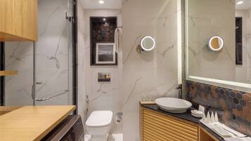 A modern bathroom with a toilet, sink, and shower.