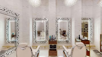 A luxurious bathroom with three large mirrors, marble walls, and a vanity with a gold bar.