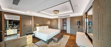 A modern bedroom with a large bed, bedside tables, a bench, a vanity, and a mirror.