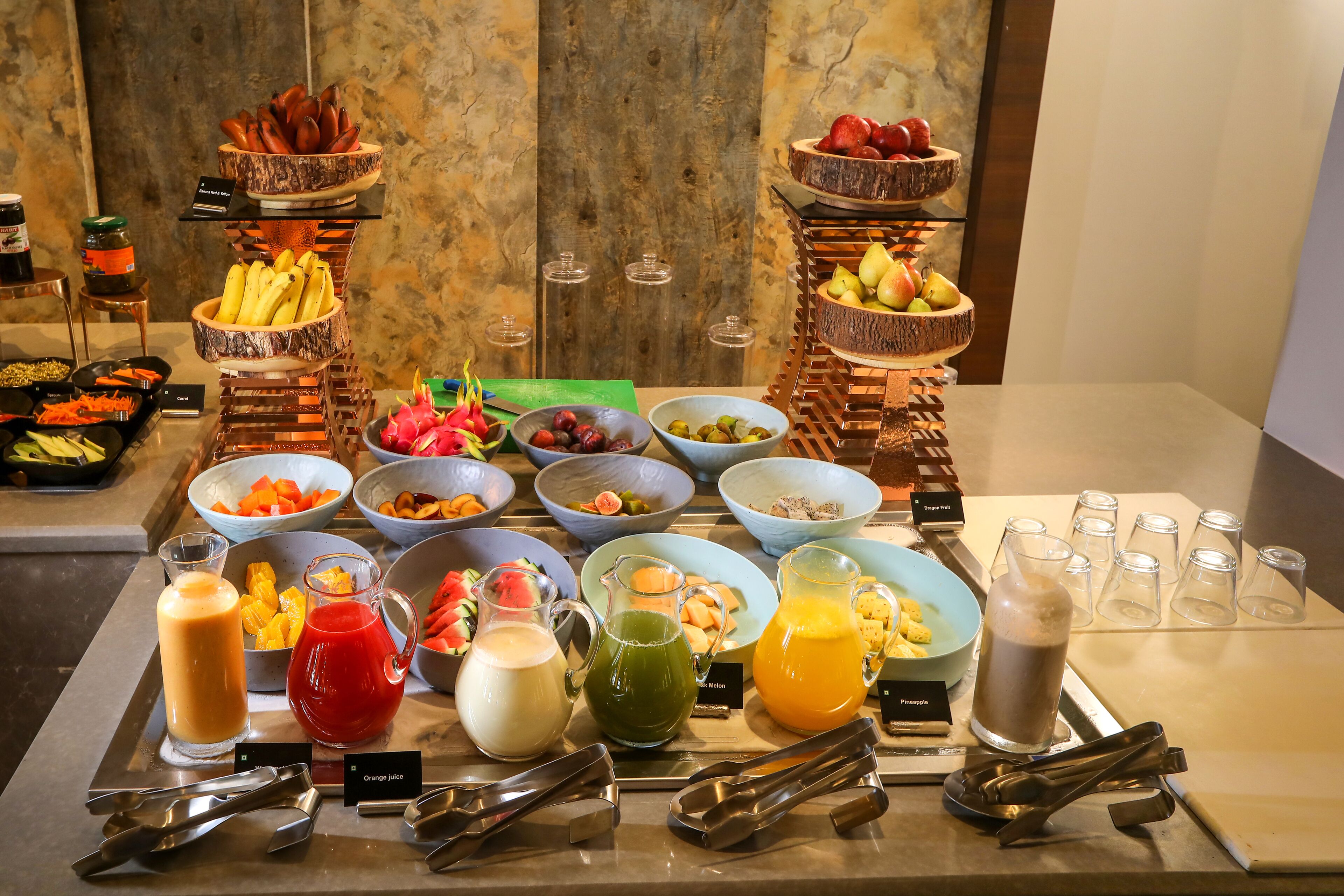 Ein reichhaltiges Buffet mit verschiedenen Speisen und Getränken, darunter Obst, Gemüse und unterschiedliche Saftsorten.