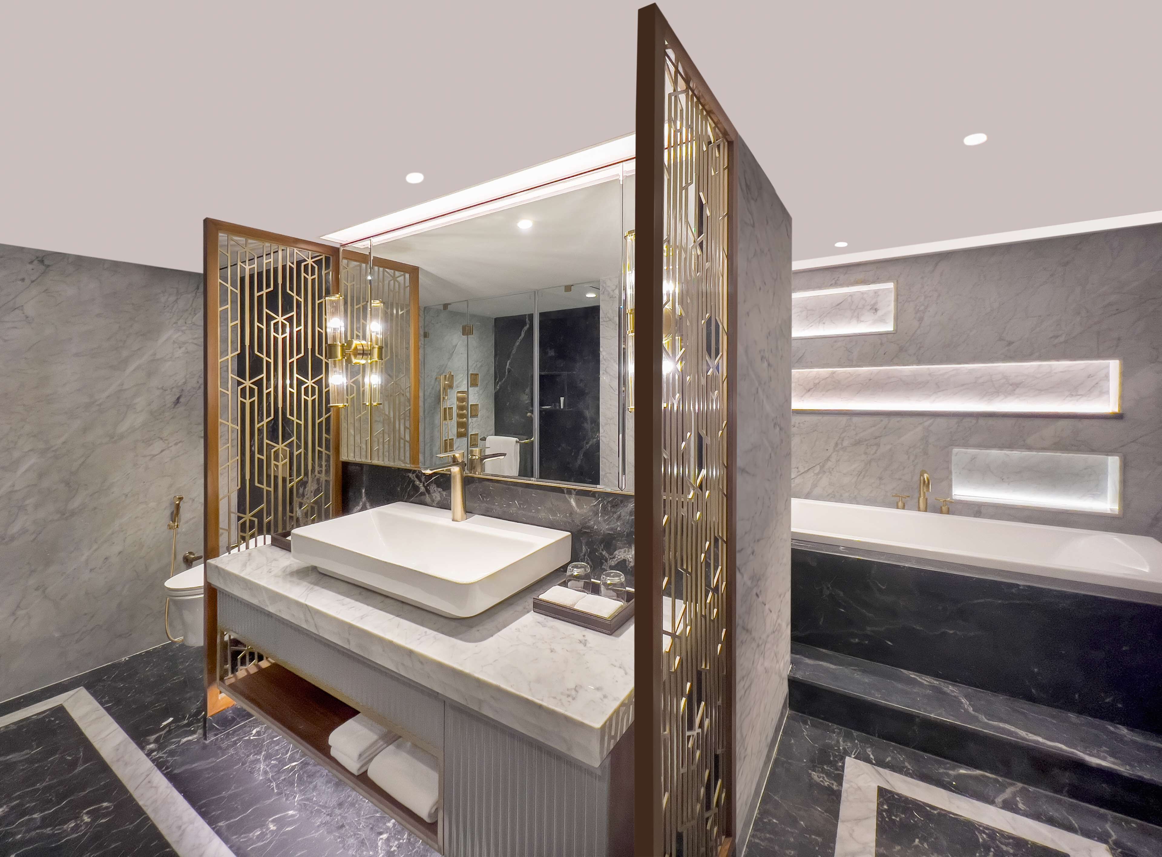 A modern bathroom with a large mirror, two sinks, and a bathtub.