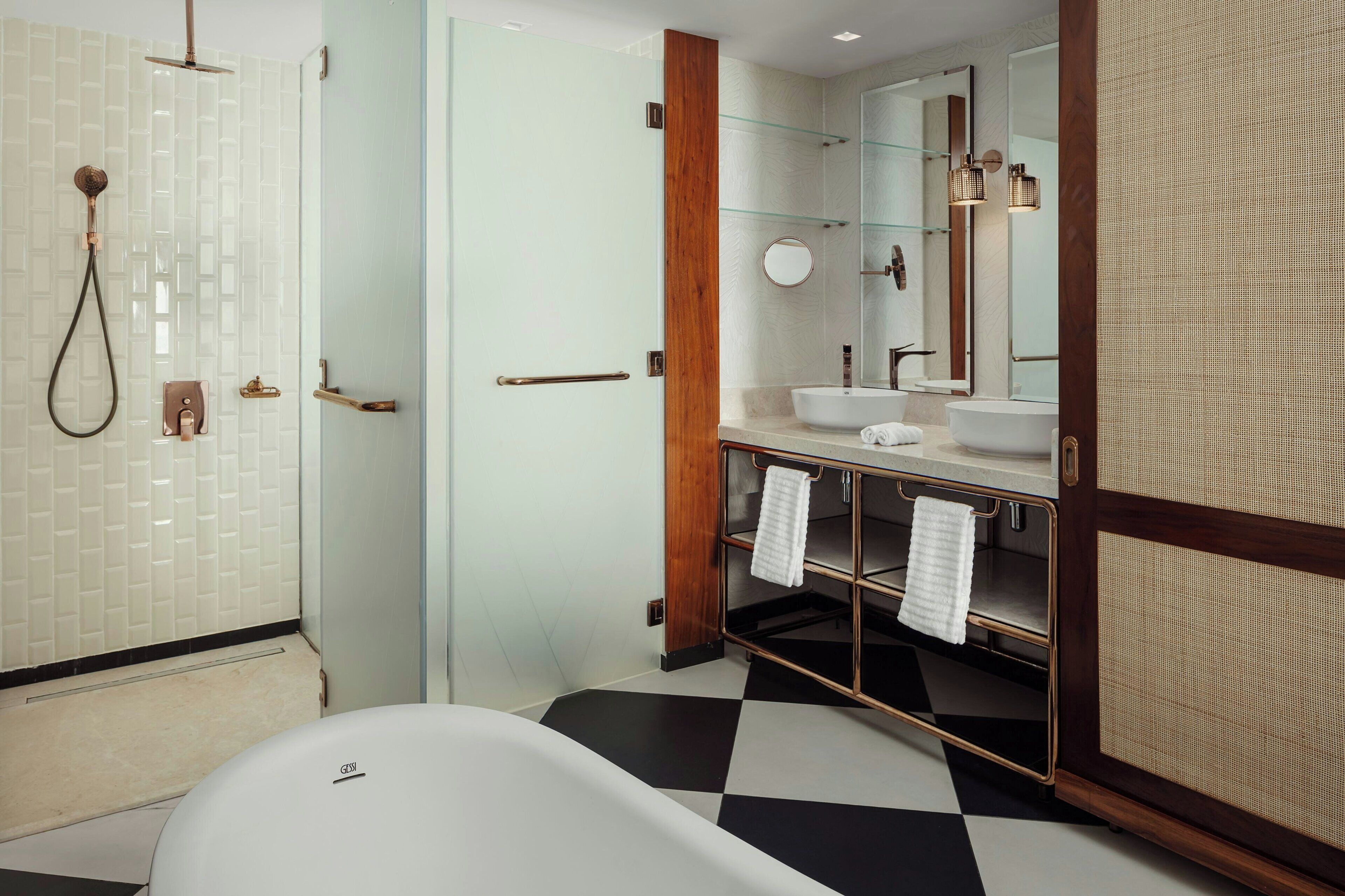 Ein modernes Badezimmer mit einer freistehenden Badewanne, einer Duschkabine aus Glas und einem Waschtisch mit Spiegel und Handtuchhalter.