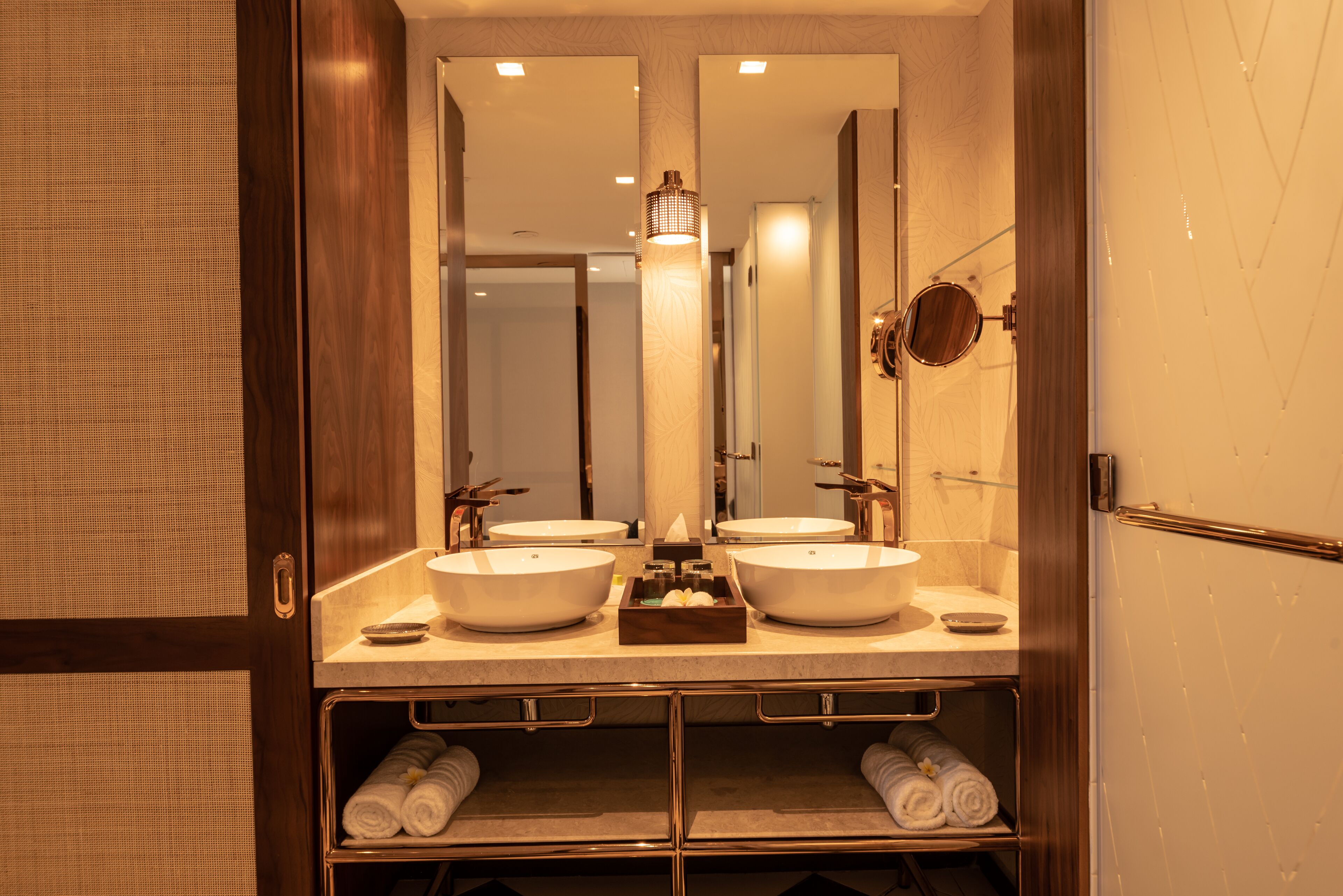 A bathroom with two sinks, a mirror, and a towel rack.