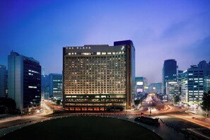 A modern hotel with a central courtyard, multiple floors, and a prominent entrance.