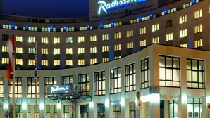 A Radisson hotel with multiple floors, a prominent Radisson sign, and a Bistro Arcade.