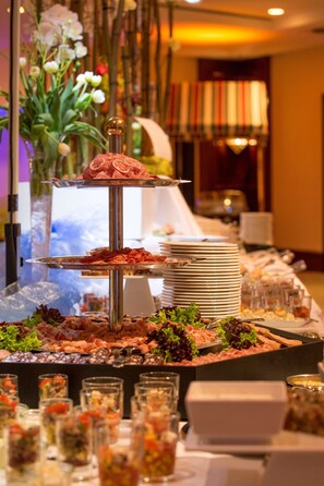 A buffet setup with multiple serving platters and glassware.