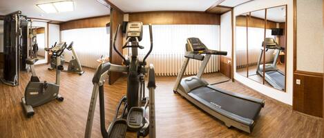 A gym with treadmills, elliptical machines, and weight equipment.