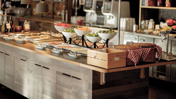 A modern kitchen with a central island, overhead pendant lighting, and a variety of kitchen appliances and utensils. - Quality Hotel Royal Corner (Växjö)