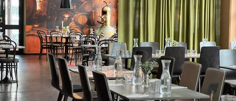 A restaurant interior with tables, chairs, and a mural of barrels.