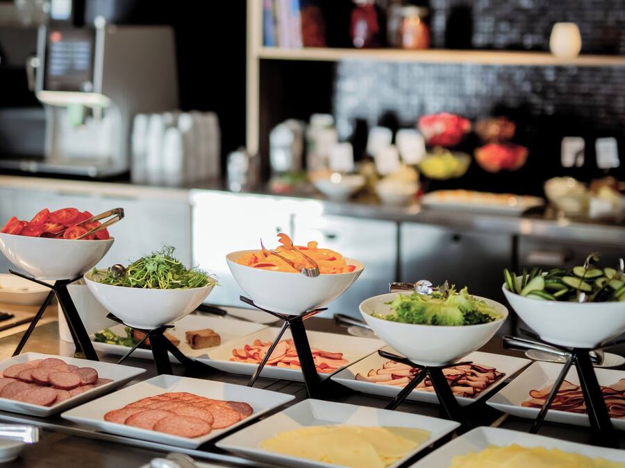 Ein Buffet mit verschiedenen Speisen und eine Küchenzeile im Hintergrund.
